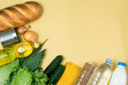 Essential fresh products lie on a yellow background. Greens food. Food delivery covid-19 epidemic,...