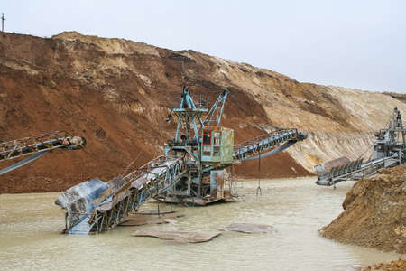 Clay quarry near the town of Pology in the Zaporizhya region of Ukraine flooded heavy rains. Equipment for mining of refractory clay - conveyor loader self-propelled crawler electric. March 2006の写真素材