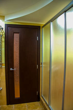 veneered wooden door in the hallway near the mirror with a welded installationの写真素材