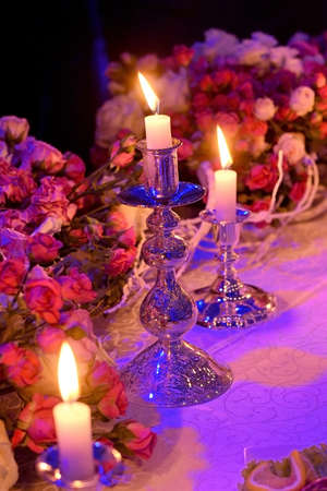 wedding table setting decorated with burning candles and flowersの写真素材