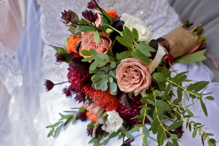 wedding bouquet with claret dahlias orange and cream rosesの写真素材