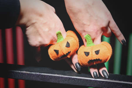female hands with black manicure playing with puppets in form pumpkins for Halloween on fingersの写真素材