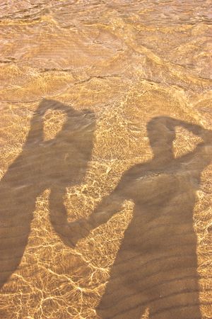 shadow of young girls and a guy in the sea waterの写真素材