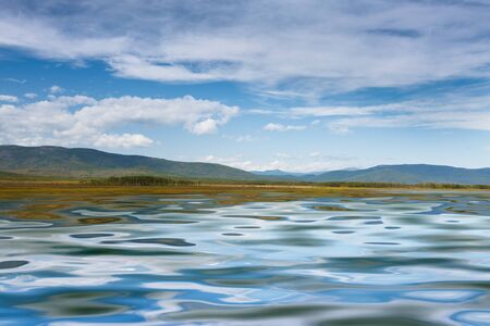 azure lake with a reflection of the clouds of heaven at the foot of the mountainsの写真素材