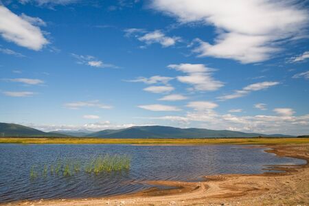 azure lake with a reflection of the clouds of heaven at the foot of the mountainsの写真素材