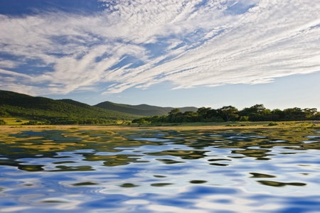 azure lake with a reflection of the clouds of heaven at the foot of the mountainsの写真素材