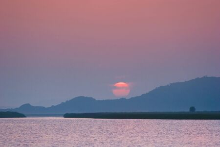 wonderful landscape, the crimson sun descends to the seaの写真素材