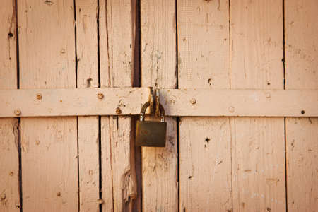 an old rusty lock hanging on the gateの写真素材