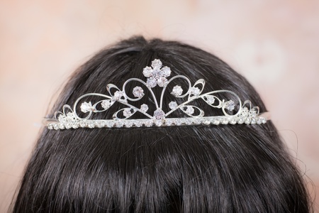 Beautiful tiara with artificial diamonds on the head of a girl with dark hairの写真素材