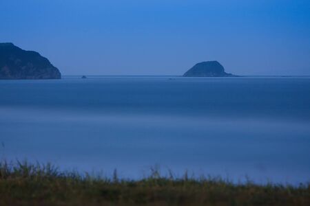 waterscape, emerald forest and marine blue combines the thin strip of beachの写真素材