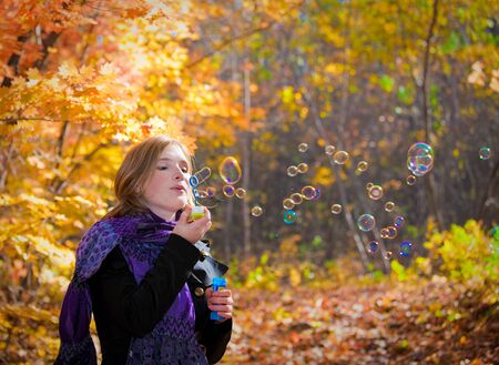 beautiful girl teen walks in the park in autumnの写真素材
