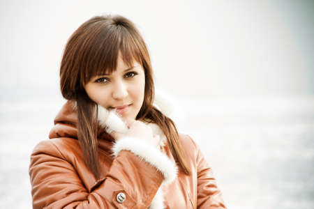 beautiful girl with brown eyes, walking on the street in winterの写真素材