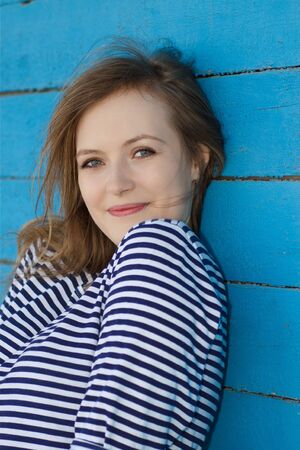 beautiful burnett on the background of old blue wallの写真素材