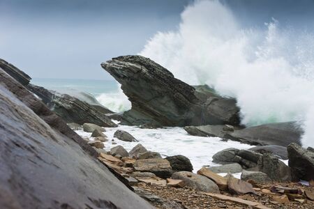 storm waves rolled on rocky shoreの写真素材