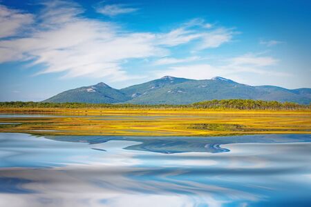 azure lake with a reflection of the clouds of heaven at the foot of the mountainsの写真素材