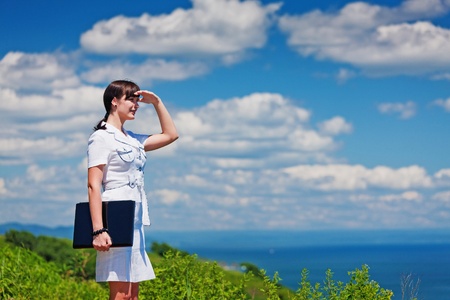 beautiful slender girl with a laptop on the natureの写真素材