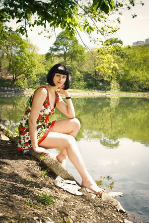 cute girl  sitting at the lakeの写真素材