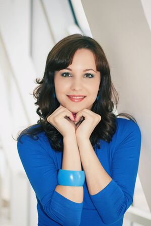 portrait of a girl in a blue dress in the white studio