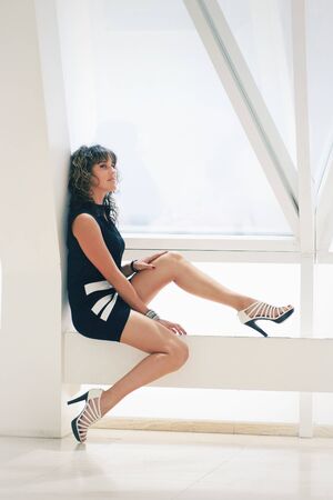 fashion girl portrait sitting on a light boxの写真素材