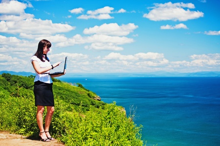 beautiful girl in a business suit with laptopの写真素材
