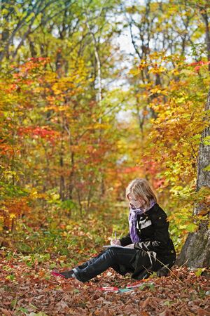 beautiful girl teen walks in the park in autumnの写真素材