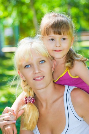 Mother and daughter playing in the meadow in the parkの写真素材
