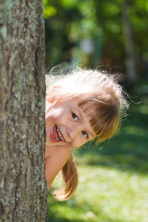 little girl playing in the meadow in the parkの写真素材
