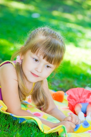 little girl playing in the meadow in the parkの写真素材