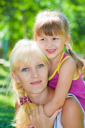 Mother and daughter playing in the meadow in the parkの写真素材