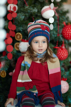 little girl in a celebratory dress near Christmas treeの写真素材