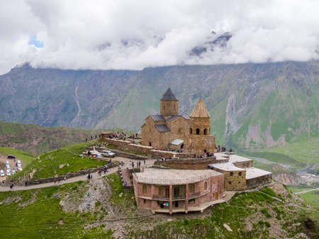 Georgia - June 10, 2018: tourists visiting the Trinity Church in Gergeti, aerial shoot