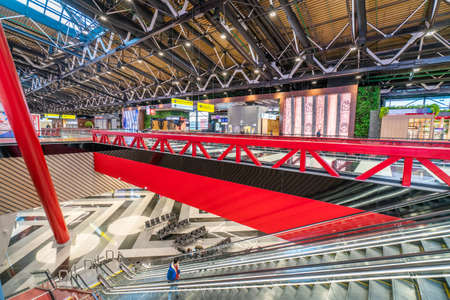 Moscow, Russia - 2020: Sheremetyevo International Airport, Terminal inside. The interior of the 1st and 2nd floors: an escalator, chairs, red railings, signs and shop windows.のeditorial素材