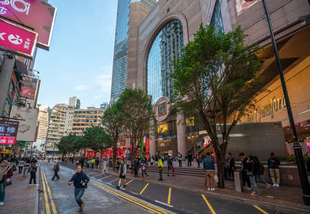 Hong Kong - 2020: Russell Street, Times Square mall entrance, people stand on the sidewalk and cross the road.のeditorial素材