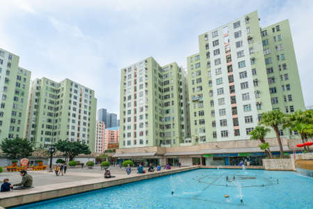 Hong Kong - 2020: fountain near Telford Plaza I, people walk and relax on the street, buildings facades, Kowloon Bay.のeditorial素材