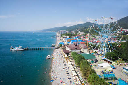 Lazarevskoe, Russia - 2016: Black sea, people on the beach, park and ferris wheel from above. Summer vacation.のeditorial素材