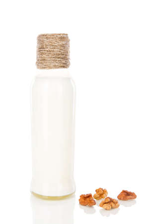A bottle of milk cocktail shake yoghourt with peeled walnuts white background isolatedの写真素材