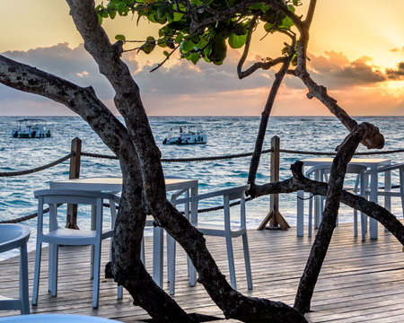 Wooden table and chairs on the beach at sunrise, Punta Cana.の写真素材