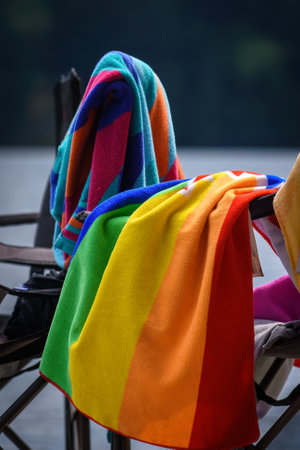 Colorful towels on a folding chair at the lake.の写真素材
