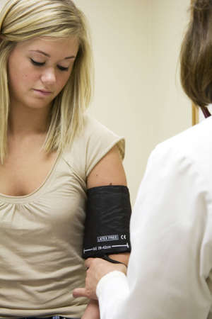 Model Release 307  A doctor examining a teenage female patient  Having her blood pressure checked