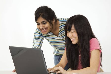 Asian and East Indian teenagers looking surprised by what they found on the laptop computerの写真素材