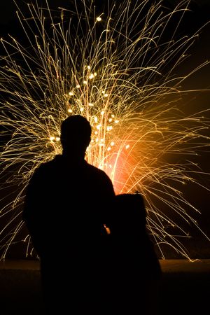 Father and daughter silhouetted while watching fireworks on the 4th of July celebrationの写真素材