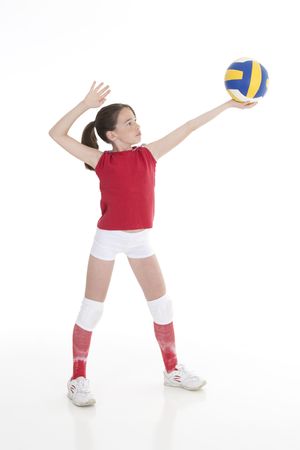 Cute Caucasian girl serving the ball in volleyballの写真素材