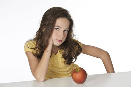 Cute Caucasian girl unhappy about eating an appleの写真素材