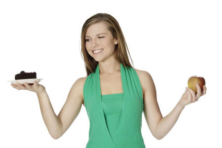 Cute Caucasian woman trying to make a decision between eating healthy or notの写真素材