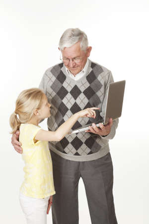 Cute Caucasian granddaughter showing her grandfather something on the computer