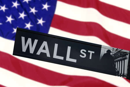 Wall street sign in front of the United States Flag