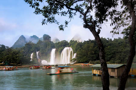 Tourist boats viewing Detian Waterfalls in China, also known as Ban Gioc in Vietnam is the fourth largest transnational waterfalls in the world. Located in Karst hills of Daxin County, Guangxi Province, China and TrÃ¹ng KhÃ¡nh District, Cao Báº±ng Vietnamの写真素材
