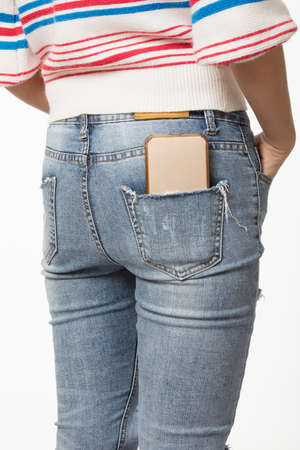 Sexy woman with a cell phone in her back pocket on a white backgroundの写真素材