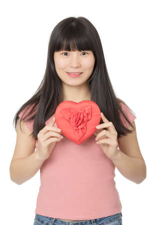 Asian woman enjoying a special gift of a box of chocolates in a red heart isolated on a white backgroundの写真素材