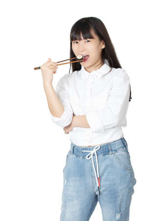 Beautiful Chinese American woman holding sushi with chopsticks isolated on white backgroundの写真素材